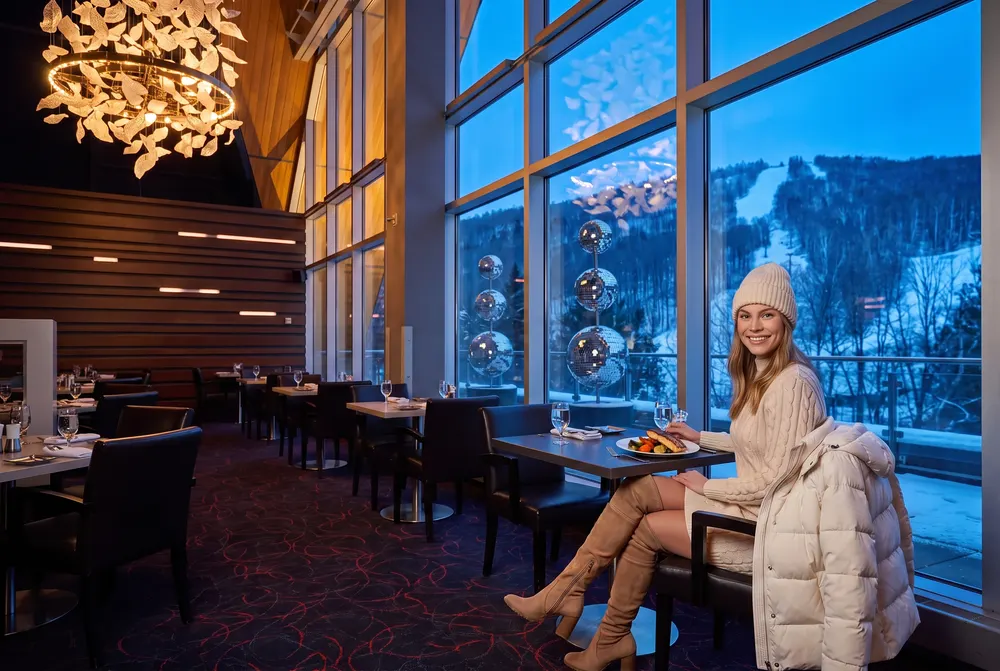 Jeune femme au restaurant Altitude, face aux pistes